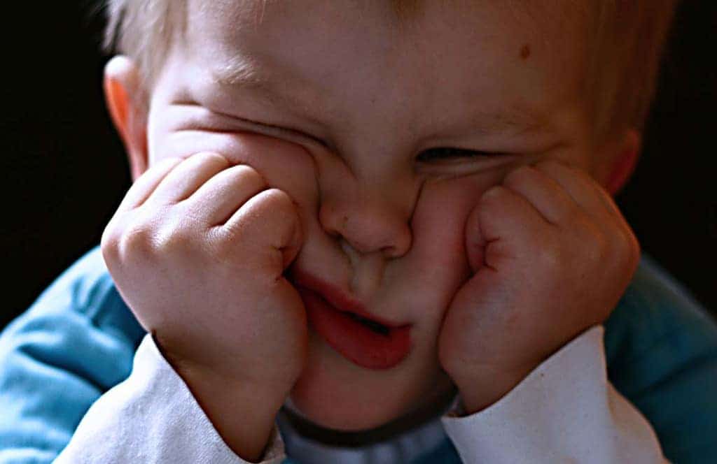 Frustrated toddler with wrinkled face closeup