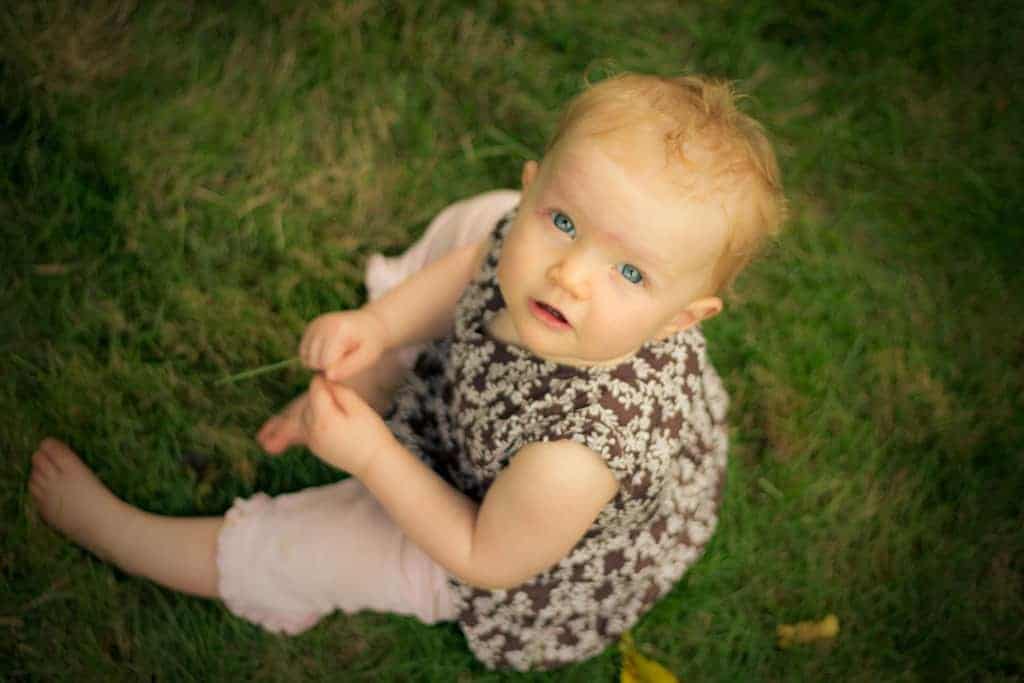 Nine month old Grace sitting on grass