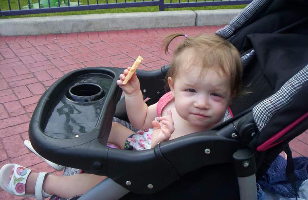 Toddler girl with pinkeye sitting in stroller
