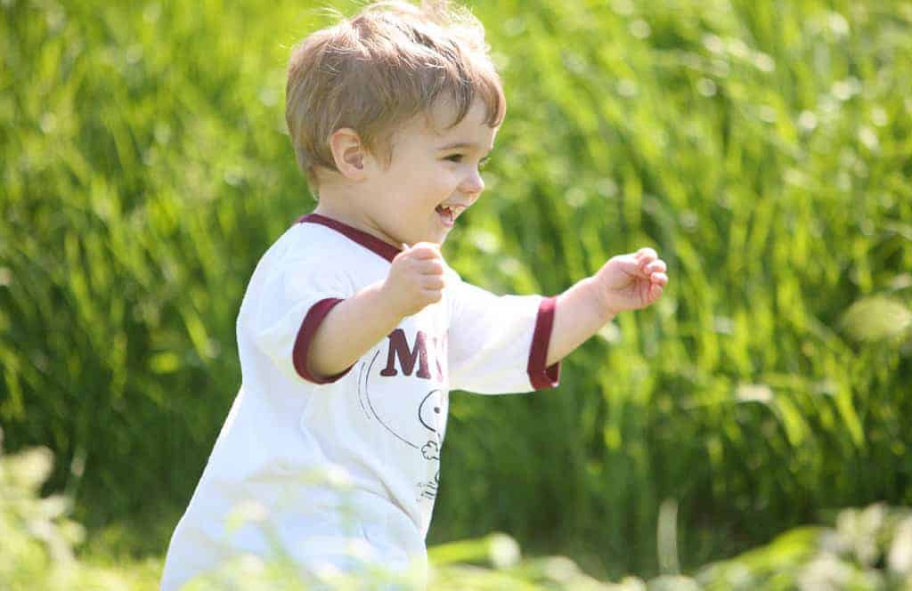 Toddler running through grass