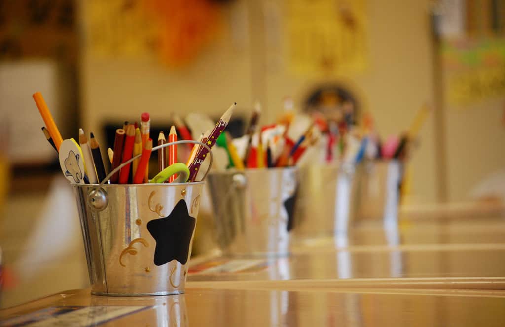 Buckets of school supplies desks