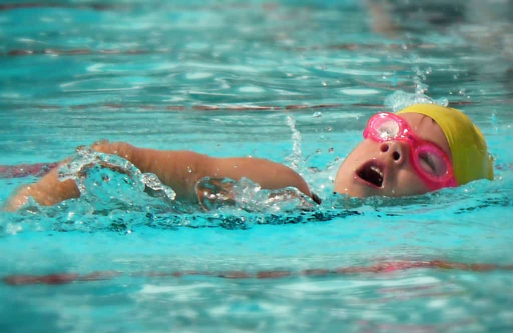 Girl swimming in pool at swim meet