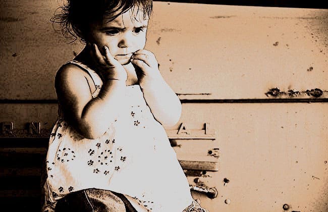 Toddler with hands on face looking worried