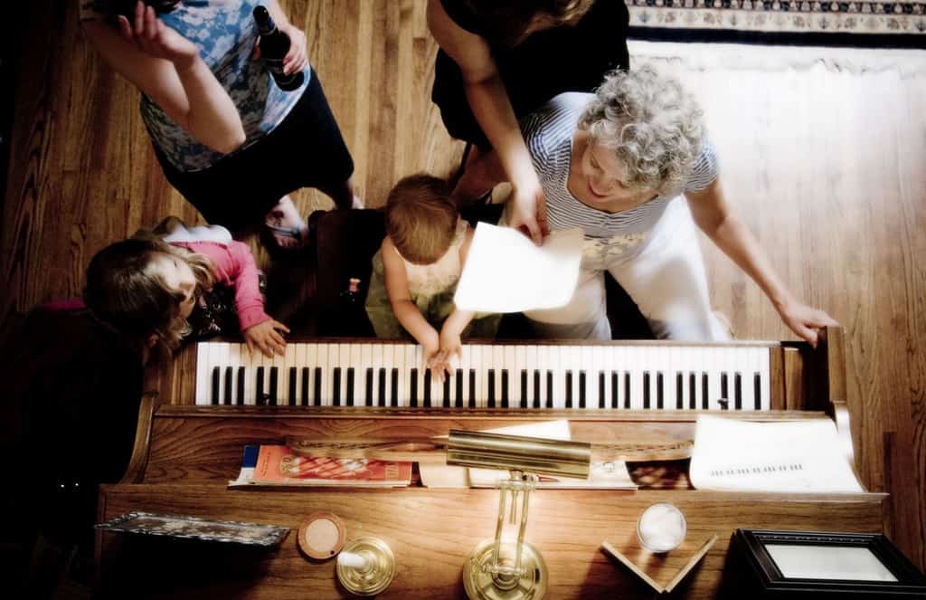 Baby, Grandmother, Sister, and Mom playing at the piano